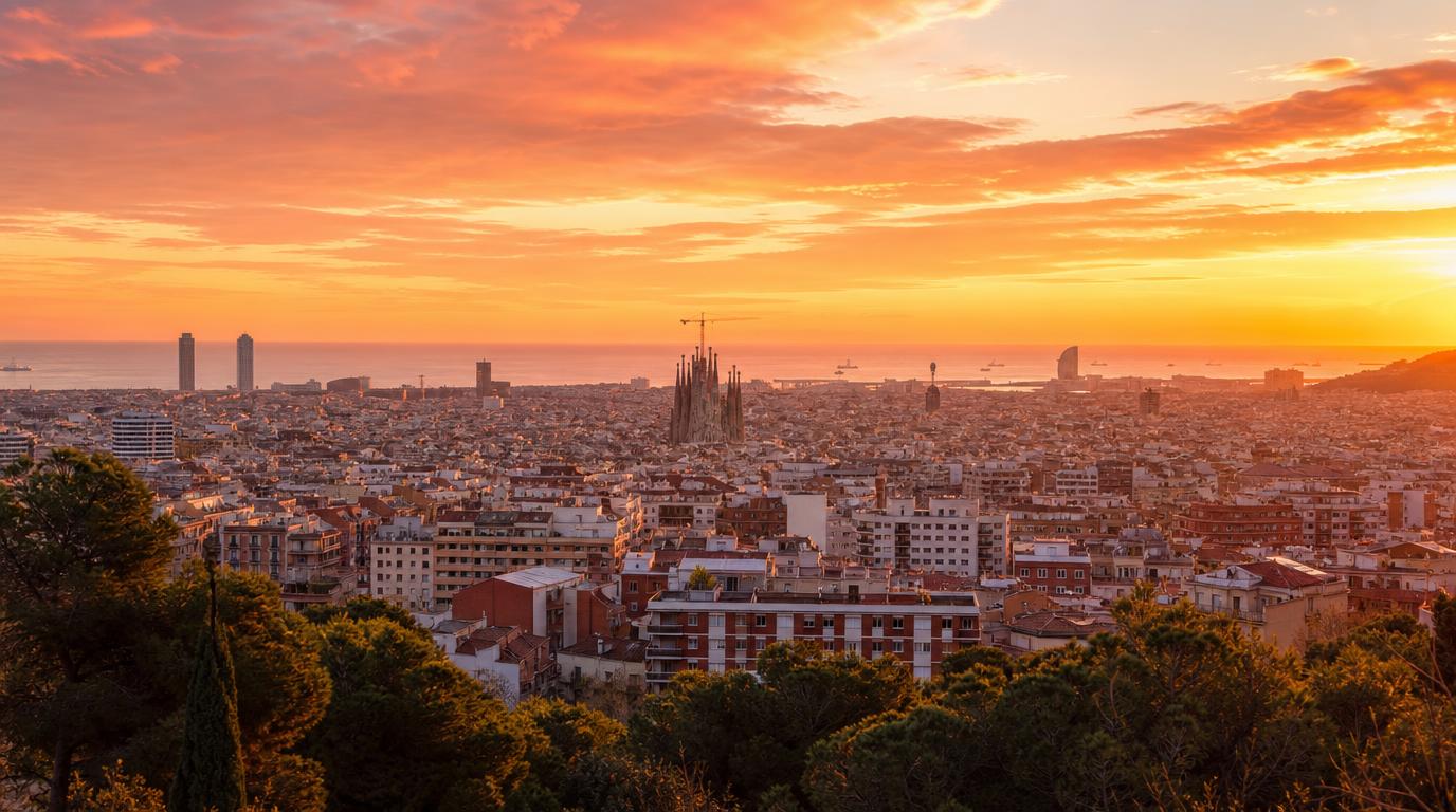 Wide landscape shot of Barcelona's skyline at golden hour, seen from a hillside like Montjuïc or Bunkers del Carmel, terracotta rooftops