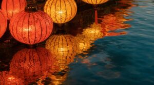 Close, textural shot of traditional silk lanterns reflected in the still water of the Thu Bon River at dusk in Hoi An's Ancient Town,