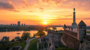 Wide golden-hour landscape shot of Kalemegdan Fortress ramparts overlooking the confluence of the Danube