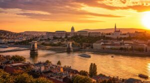 Wide golden-hour skyline shot of Budapest looking across the Danube toward Buda Castle and the Chain Bridge